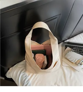 Interior view showing the large capacity of the beige canvas tote bag with daily essentials