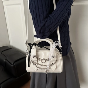 White semi-circle crossbody bag with silver chains, cross pendant and lace ribbon details