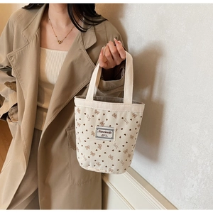 Detail of cute strawberry print corduroy handbag with soft bow and heart patterns
