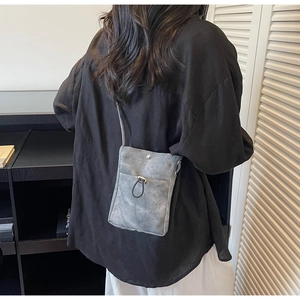 Pochette téléphone grise en toile mate avec cordon et bouton pression porté par modèle