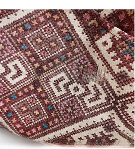 Vue macro du tissu jacquard ethnique aux motifs géométriques tissés rouge et marron