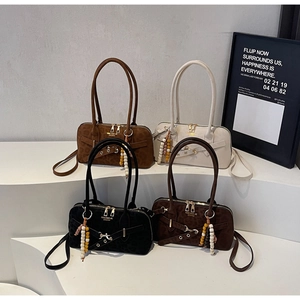 Detail of premium suede tote bags with beaded tassel charms and metallic ring accents