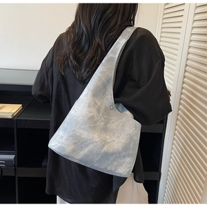 Detailed texture of light blue minimalist tote bag with metal rivet and wide strap
