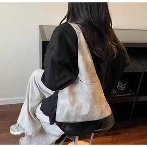 Detailed side view of large grey tote bag with matte texture and metallic hardware detail