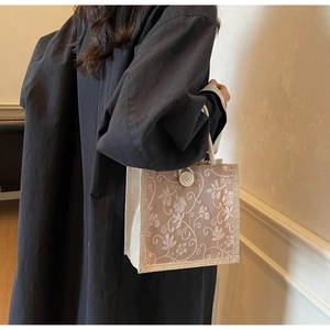 Detailed view of linen tote bag with jacquard floral pattern and white rope handle