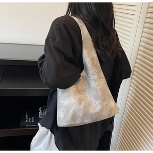 Close-up of a marble textured grey tote bag shown from a shoulder carry perspective