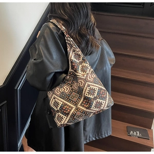 Sac fourre-tout ethnique à motifs géométriques porté avec un élégant manteau en cuir noir