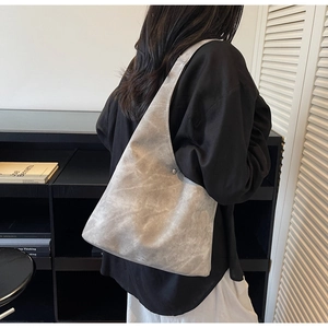 Detail of grey large capacity tote bag featuring vintage textured matte finish and stitching