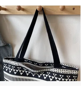 Detail of canvas tote bag with black and white geometric pattern and sturdy handle