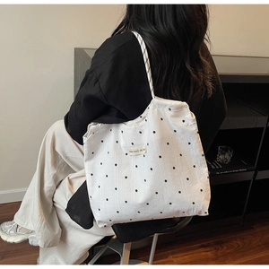 Detailed texture of white floral canvas tote bag with small black flower patterns