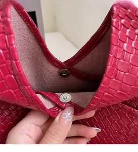 Detail of red woven tote bag showing internal magnetic closure and satin lining