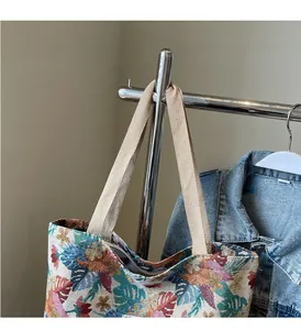Close-up of ethnic floral tote bag fabric with woven handles and botanical patterns