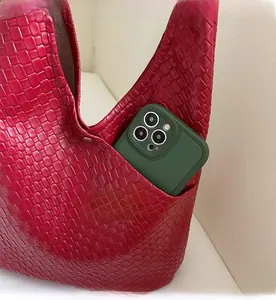 Close-up of red woven tote side pocket showing storage capacity for a smartphone