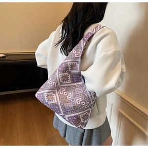 Gros plan d'un sac cabas violet à motif géométrique porté à l'épaule par un mannequin