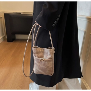 Détail du mini sac à bandoulière marron en toile avec poche avant à cordon de serrage