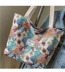 Close-up of a large tote bag featuring colorful tropical floral jacquard weave and soft handles