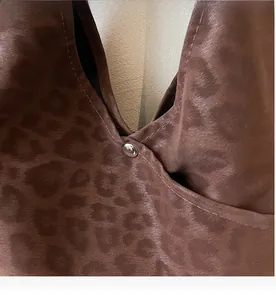 Detail of leopard print tote bag showing stitching and silver metal snap closure
