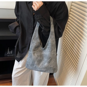 Detail of the gray washed suede texture tote bag featuring a silver metal snap button closure