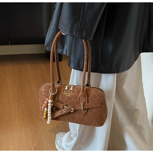 Detail of brown leopard print handbag with beaded tassel and metal belt accents