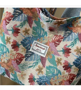 Detail of ethnic jacquard woven tote bag showing tropical leaf patterns and brand label