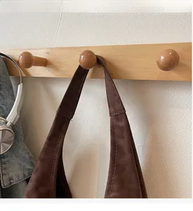Detail of soft brown PU leather tote bag strap with reinforced stitching on a hook