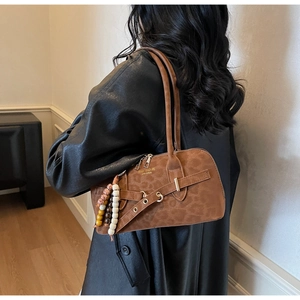 Detail view of brown leopard textured handbag with decorative belt buckle and beads