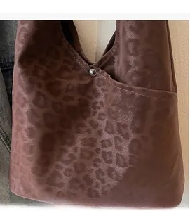 Detail of soft leopard print tote bag with silver metal buckle and vintage suede texture