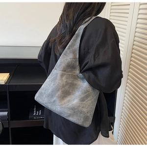 Detail of grey suede shoulder bag texture and stitching during everyday commute wear