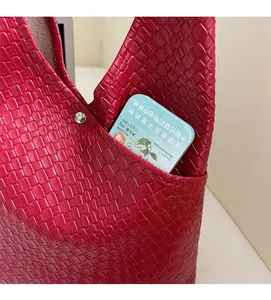 Detail view of the red woven tote bag showing internal pocket and crocodile texture