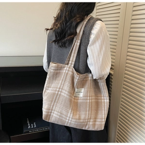Detail of checkered tote bag fabric showing beige and white patterns with a square tag