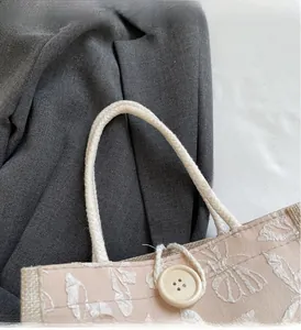 Detail of floral jacquard lunch bag with sturdy cotton rope handles and button closure