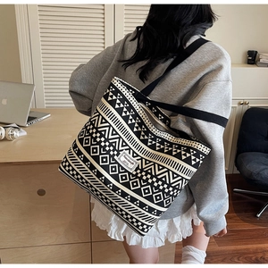 Detail of large canvas tote bag with black and white geometric pattern and wide strap