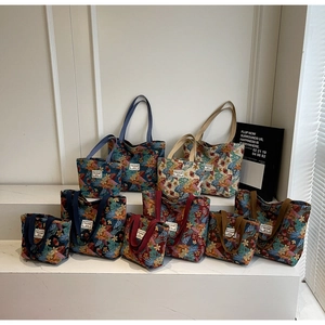 Various sizes of canvas tote bags with vintage floral prints and colorful handles