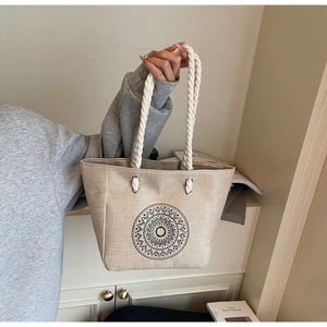 Detail of the large linen tote bag showing the white rope handles and mandala print design
