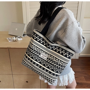 Side view of large canvas tote bag with black and white geometric tribal patterns