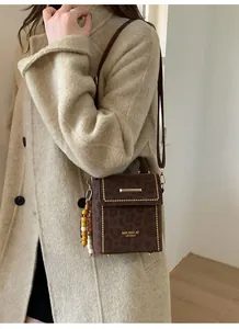 Detail of leopard print bag with gold studs, ethnic beads, and leather shoulder strap