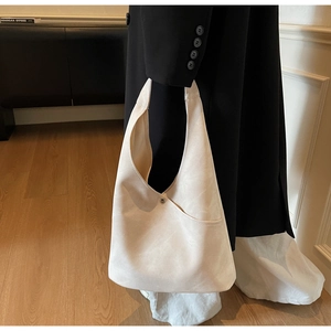 Detailed view of cream minimalist tote bag with metal button detail and spacious interior