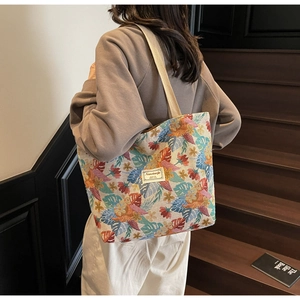 Detail of colorful floral jacquard tote bag with tropical patterns and shoulder strap