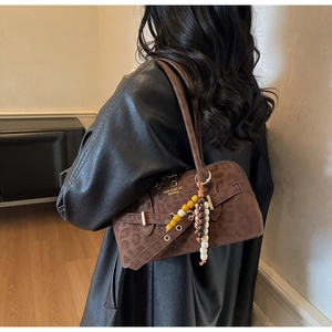 Detail of dark brown leopard print shoulder bag with retro beaded charm and metal buckle