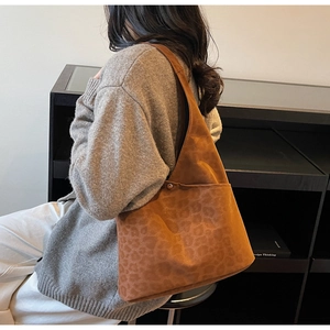 Detail of large brown leopard print tote bag in matte suede texture with side metal buckle