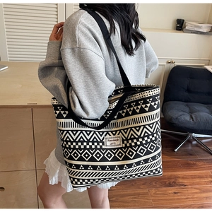 Detailed side view of a large canvas tote bag with black and white ethnic geometric patterns
