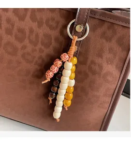 Ethnic style beaded tassel charm with yellow and brown wood beads on a leopard tote bag