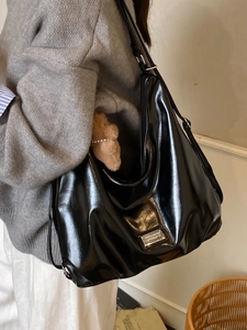 Black large capacity glossy leather tote bag shown on model for daily commuting style