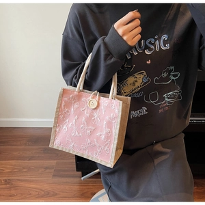 Detailed close-up of pink tote bag with 3D white butterfly embroidery and rope handles