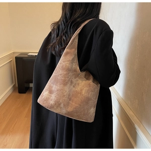 Close-up of vintage brown large capacity hobo bag with distressed suede texture and rivets