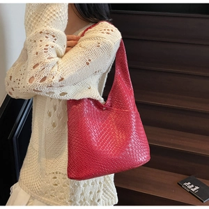 Detail of red woven texture on a large capacity tote bag worn with cream knitwear