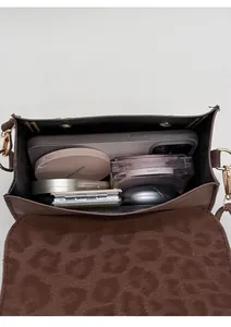 Interior view showing leopard print lining and capacity for smartphone and cosmetics