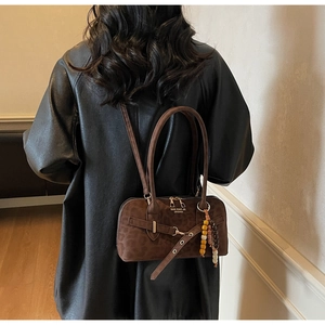 Detail of brown suede handbag with vintage gold hardware and decorative colorful beads