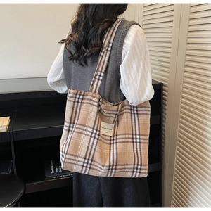 Close-up of brown plaid tote bag texture and branded woven label on thick cotton canvas