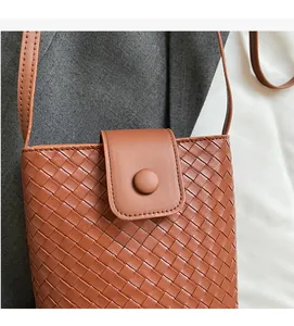 Close-up of brown woven bucket bag featuring detailed PU texture and button closure